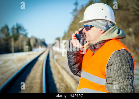 Railway engineer talking on the cell phone on railway Stock Photo