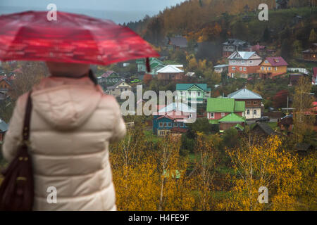 A woman under an umbrella looking down on the old Russian town Ples in Ivanovo region during autumn rain, Russia Stock Photo