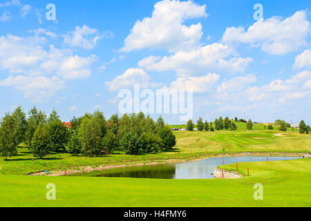 PACZULTOWICE GOLF CLUB, POLAND - AUG 9, 2014: lake on golf course green play area on sunny summer day. Golfing is becoming a popular sport among wealthy people from Krakow. Stock Photo