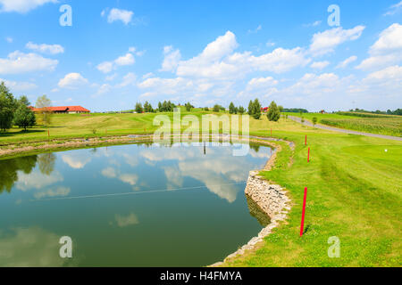 PACZULTOWICE GOLF CLUB, POLAND - AUG 9, 2014: lake on golf course green play area on sunny summer day. Golfing is becoming a popular sport among wealthy people from Krakow. Stock Photo