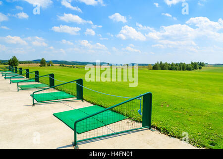 PACZULTOWICE GOLF CLUB, POLAND - AUG 9, 2014: Long range shooting station at beautiful golf play area on sunny summer day. Golfing becomes popular sport among wealthy Poles. Stock Photo