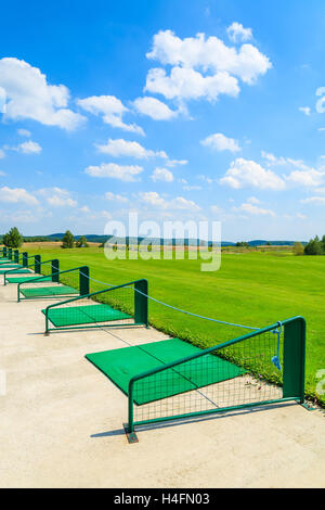 PACZULTOWICE GOLF CLUB, POLAND - AUG 9, 2014: Long range shooting station at beautiful golf play area on sunny summer day. Golfing becomes popular sport among wealthy Poles. Stock Photo