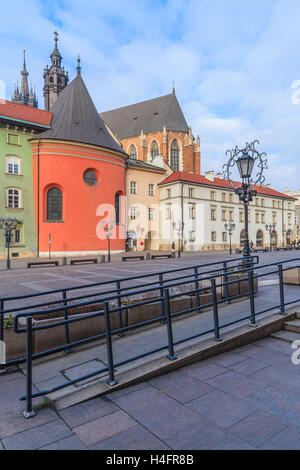 KRAKOW, POLAND - DEC 10, 2014: Mariacki church and colourful houses on square in Krakow. Many tourists visit Krakow which is most popular destination in Poland. Stock Photo