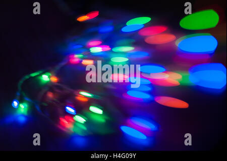 Colorful beautiful multi-colored Christmas lights on a black background Stock Photo