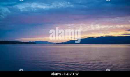 Pink and orange sunset over hills and water in Tasmania, Australia. Stock Photo