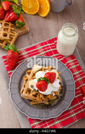 Belgian waffles with chocolate, bananas and strawberries, syrup-drenched Stock Photo