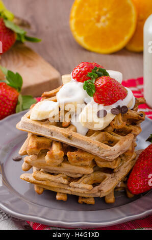 Belgian waffles with chocolate, bananas and strawberries, syrup-drenched Stock Photo