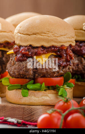 Beef Sliders with homemade barbecue sauce, cheddar, cherry tomatoes and microgreens Stock Photo