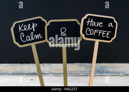 Keep Calm and Have A Coffee message written with chalk on mini blackboard labels Stock Photo