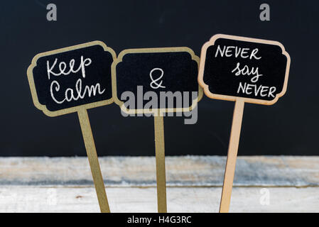 Keep Calm and Never Say Never message written with chalk on mini blackboard labels Stock Photo