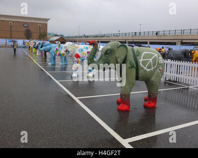 Meadowhall, Sheffield, UK. 16th October 2016. UK Weather: Despite heavy rain, a crowd of people attends the Herd of Sheffield Farewell event in the car park of Meadowhall shopping centre. The herd of 58 elephants, which have each been designed by a different artist, have been spread across various Sheffield locations over the summer. They have been brought together for the first time this weekend prior to being auctioned off to raise funds for Sheffield Children's Hospital Charity. Richard Bradley / Alamy Live News Stock Photo