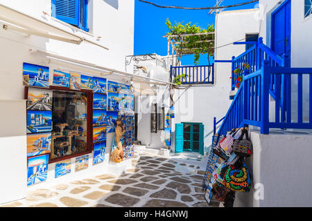 MYKONOS TOWN, GREECE - MAY 16, 2016: shop with typical for Greek islands paintings and souvenirs on whitewashed street in beauti Stock Photo