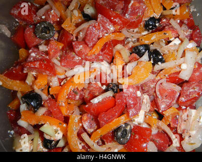 Multicolored salad with cream cheese, red tomatoes, white onion, black olives, red and yellow paprika Stock Photo