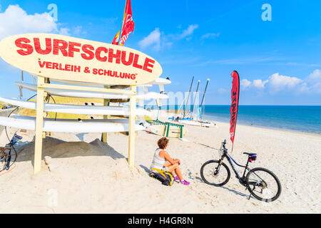 SYLT ISLAND, GERMANY - SEP 6, 2016: young woman sitting on a sandy beach in List village during trip along coast of Sylt island, Stock Photo