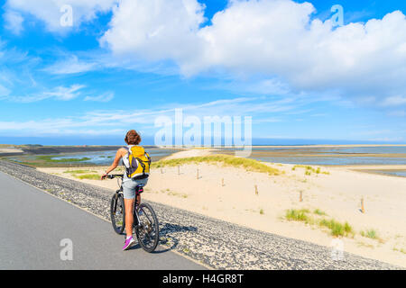 SYLT ISLAND, GERMANY - SEP 6, 2016: young woman on bike during trip along coast of Sylt island near List village, Germany. Stock Photo