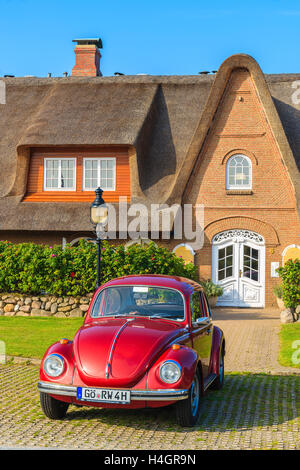 SYLT ISLAND, GERMANY - SEP 6, 2016: classic Volkswagen Beetle parked in front of typical Frisian house with thatched roof in Kam Stock Photo