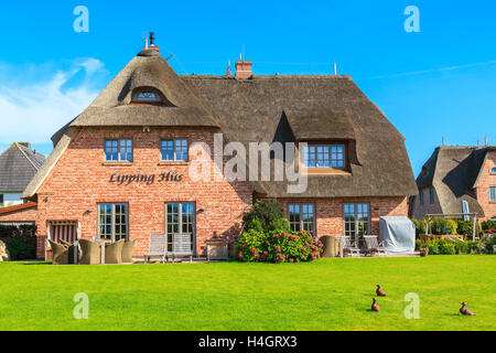 SYLT ISLAND, GERMANY - SEP 11, 2016: Traditional house with thatched roof and green garden on Sylt island in Wenningstedt villag Stock Photo