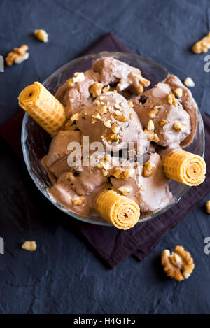 Homemade chocolate ice cream with chocolate chips and chopped walnuts in bowl close up, rustic style Stock Photo