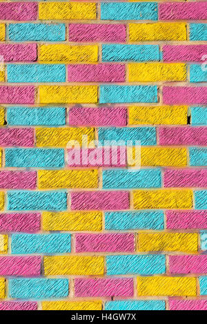 Brick wall painted in bright yellow, blue and pink colors Stock Photo