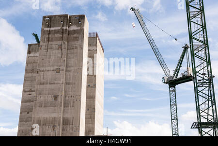 Construction site with two big cranes and concrete core of new skyscraper under construction Stock Photo