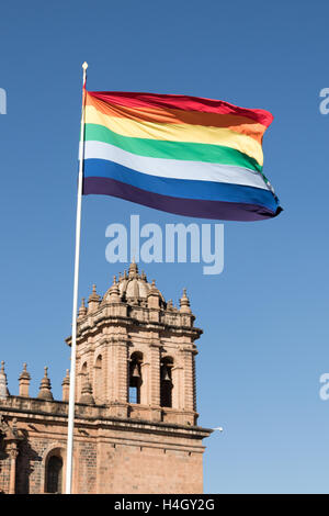 Incan rainbow flag flying proudly in the Plaza de Armas over the Templo de la Compañía de Jesús in Cusco, Peru Stock Photo