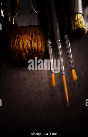Linocut tools concept. Working tools in red and black colors on dark table  with copy space. Cutting instruments, ink roller and other tools for  linocut making. High quality photo Stock Photo 