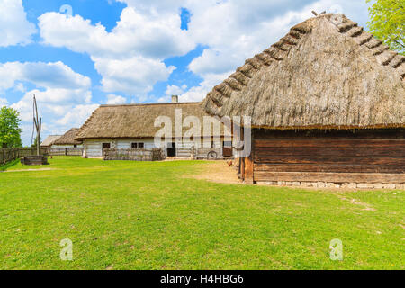 TOKARNIA VILLAGE, POLAND - MAY 12, 2016: An old rustic cottage houses on green meadow in open air museum in Tokarnia village, Po Stock Photo