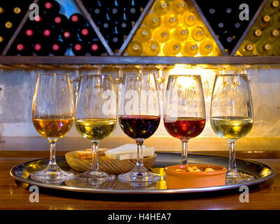 Wine tasting glasses cellar varieties tour vacation holiday trip situation in bar wine cellar Spanish Spain Bodega with selection of red and white wines with cheese and dry biscuits Stock Photo