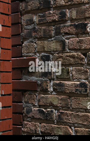 A brick wall on the side of an apartment building Stock Photo