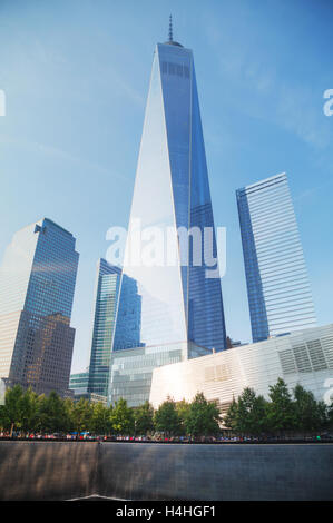NEW YORK CITY - SEPTEMBER 3: One World Trade Center and 9/11 Memorial with people on September 3, 2015 in New York City. Stock Photo