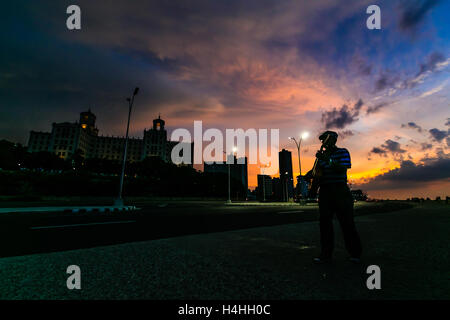 Senior man playing guitar in malecon at sunset night, Havana, Cuba Stock Photo