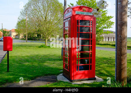 Red phone box re-purposed to house a defibrillator. Stock Photo