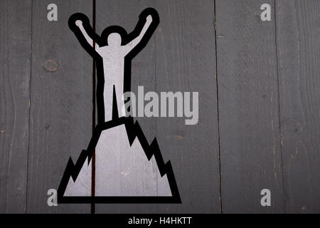 Illustration of man on top of mountain on black wooden background Stock Photo