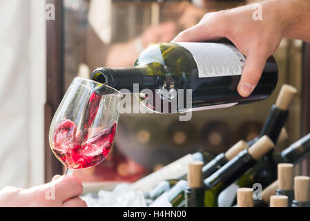 the red wine being poured into a glass close-up Stock Photo