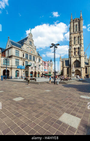 GHENT, BELGIUM - APRIL 6, 2008:  Tourists walk on Sint-Baafsplein with NTGent schouwburg and Saint Bavo's Cathedral Stock Photo