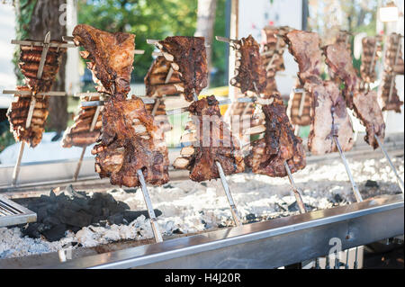 Asado, traditional barbecue dish in Argentina, roasted meat of beef cooked on a vertical grills placed around fire Stock Photo