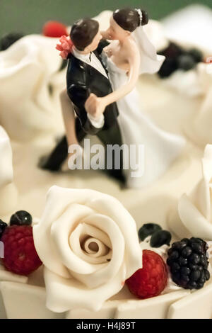 Bride and groom figurine couple on-top of Wedding cake Stock Photo