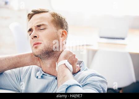 Cheerless man sitting on the couch Stock Photo