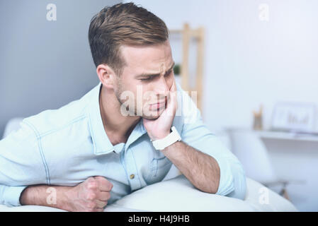 Good looking young man suffering from toothache. Stock Photo