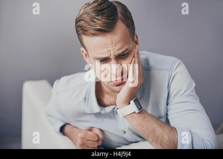 Disappointed young man having toothache. Stock Photo