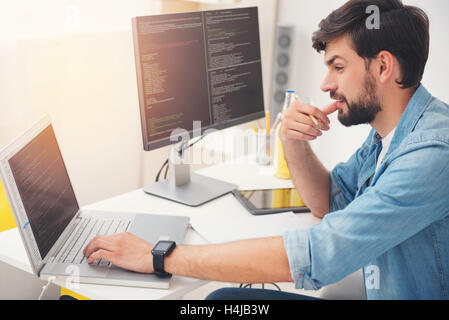 Delighted programmer working on a laptop Stock Photo