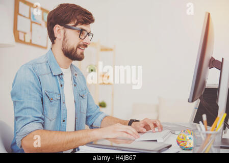 Smiling programmer in glasses working in an office Stock Photo