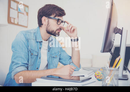 Young programmer looking at computer screen Stock Photo