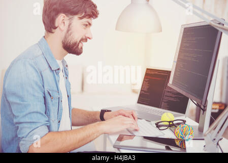 Delighted programmer doing his work enthusiastically Stock Photo