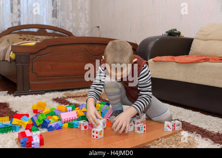 boy playing with blocks and train on the floor Stock Photo