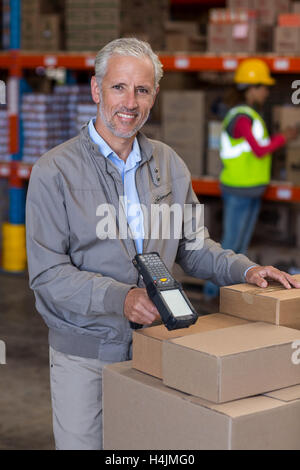 Portrait of warehouse manager scanning the boxes Stock Photo