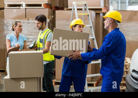 Delivery worker unloading cardboard boxes from pallet jack Stock Photo