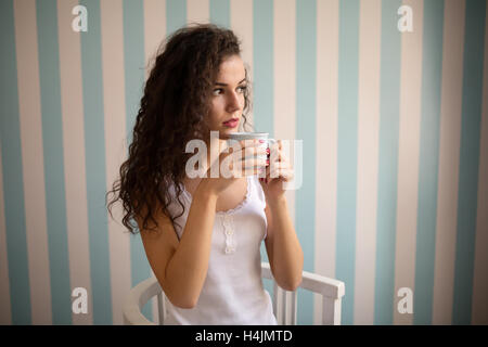 Beautiful woman with curly hair drinking coffee Stock Photo