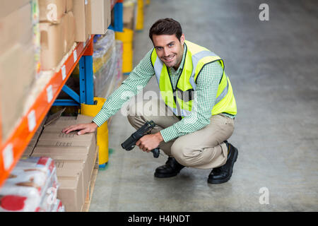 Portrait of smiling warehouse worker scanning box Stock Photo