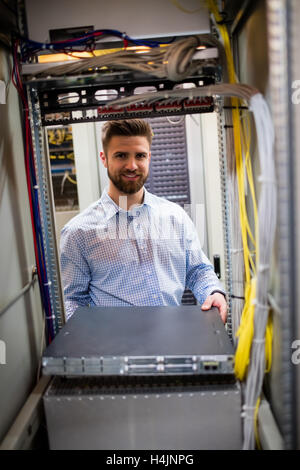 Technician removing server from rack mounted server Stock Photo